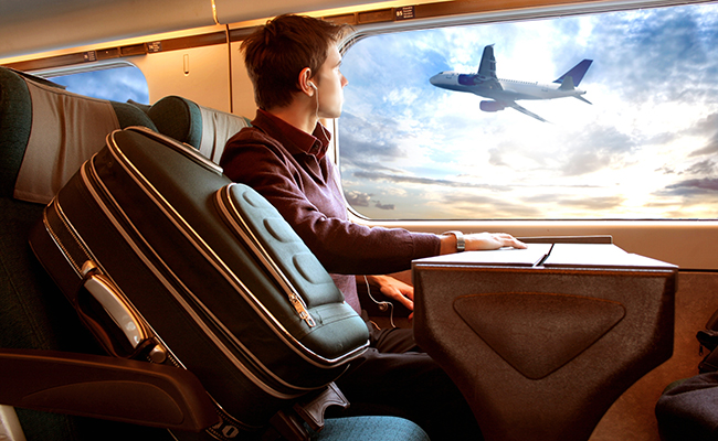 web_man-on-train-watching-plane_credit_Ollyy_shutterstock_10665658