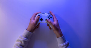 male-hands-hold-gamepad-blue-background-copy-space