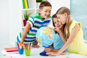 smiling-students-looking-globe (1)