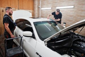 worker-detailing-garage-put-polyurethane-antigravel-film-cover-white-luxury-car (1)